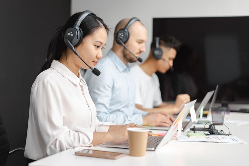 Female customer service employees wearing headsets in an office